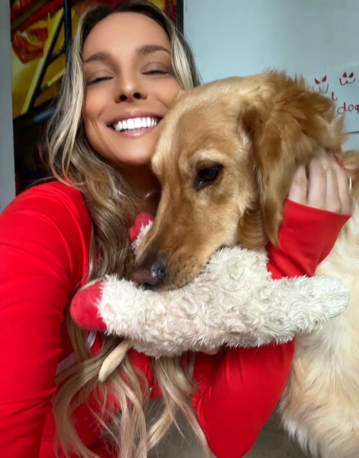 Cassie cuddling a happy golden retriever in her care