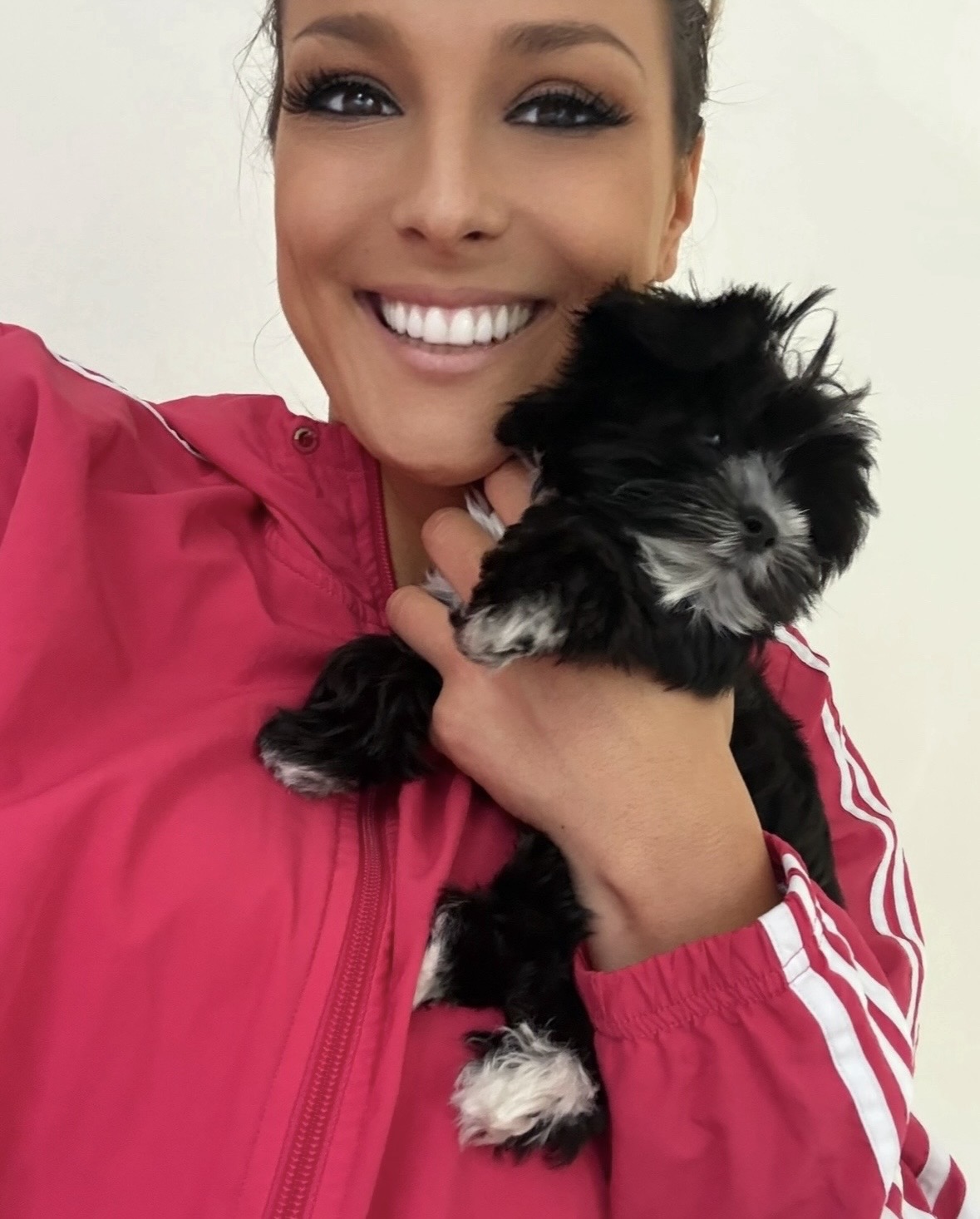 Cassie, owner of Princess Pups, holding a small black and white puppy